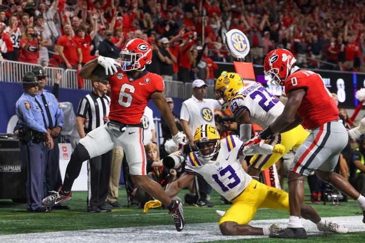 Georgia Bulldogs running back Kenny McIntosh (6) scores over LSU Tigers safety Joe Foucha (13) on an eight yard run during the second half of the SEC Championship Game at Mercedes-Benz Stadium in Atlanta on Saturday, Dec. 3, 2022. (Jason Getz / Jason.Getz@ajc.com)