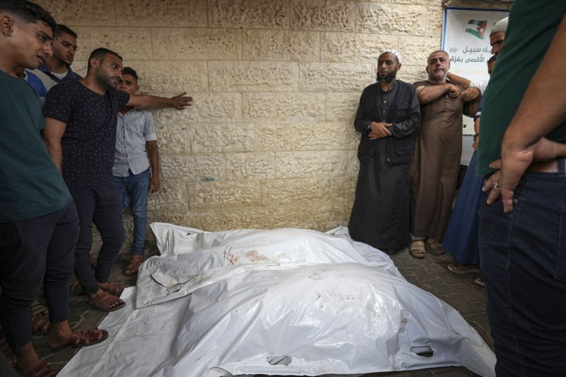 Palestinians hold a funeral for more than 15 people, including several children and women, killed in an Israeli strike, at Al-Aqsa Martyrs Hospital in Deir al-Balah, Gaza Strip, Saturday, Aug. 17, 2024. The strike hit a house and an adjacent warehouse sheltering displaced people at the entrance of the town of Zawaida, according to the hospital where the casualties were taken. (AP Photo/Abdel Kareem Hana)