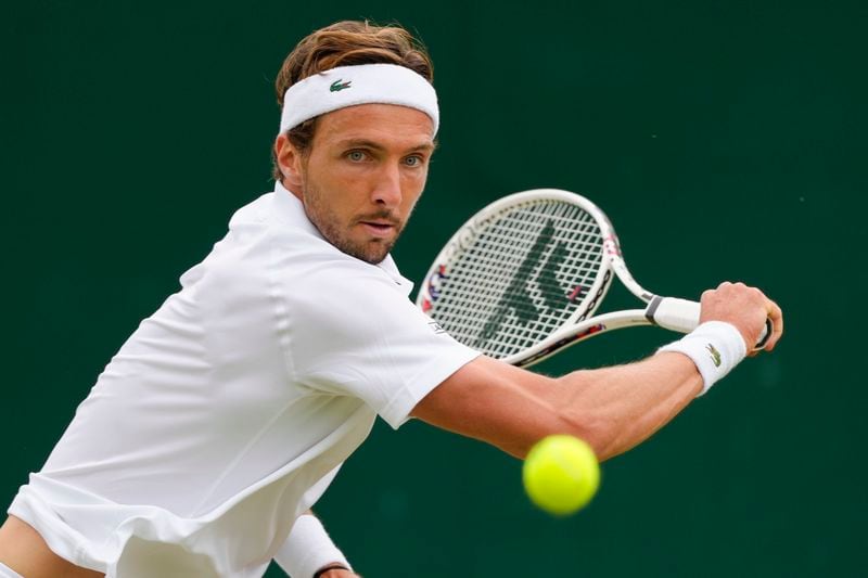 Arthur Rinderknech of France plays a backhand return to Kei Nishikori of Japan during their match on day three at the Wimbledon tennis championships in London, Wednesday, July 3, 2024. (AP Photo/Kirsty Wigglesworth)