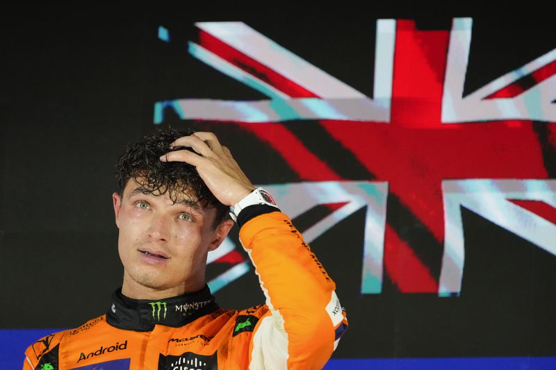 McLaren driver Lando Norris of Britain reacts on the podium after winning the Singapore Formula One Grand Prix at the Marina Bay Street Circuit, in Singapore, Sunday, Sept. 22, 2024. (AP Photo/Vincent Thian)