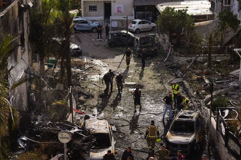 Israeli security forces examine the site hit by a rocket fired from Lebanon, in Kiryat Bialik, northern Israel, on Sunday, Sept. 22, 2024. (AP Photo//Ariel Schalit)