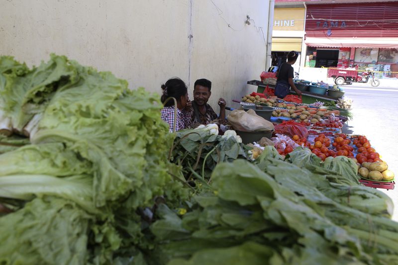 Vegetable vendors who were removed from a street wait for customers in Dili, East Timor, Saturday, Sept. 7, 2024. (AP Photo/Firdia Lisnawati)