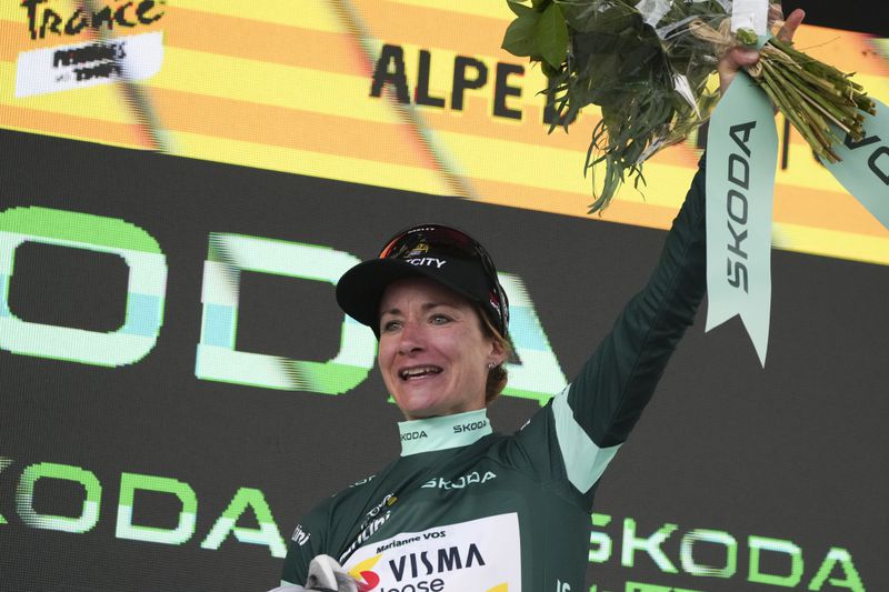 Marianne Vos of The Netherlands, wearing the best sprinter's green jersey, celebrates on the podium after the eighth stage of the Tour de France Women cycling race with start in Le Grand-Bornand and finish in Alpe d'Huez, France, Sunday, Aug. 18, 2024. (AP Photo/Peter Dejong)