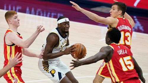 Indiana Pacers' Caris LeVert (22) looks for a shot between Atlanta Hawks' Bogdan Bogdanovic (13), Clint Capela (15) and Kevin Huerter during the second half of an NBA basketball game Thursday, May 6, 2021, in Indianapolis. (AP Photo/Darron Cummings)