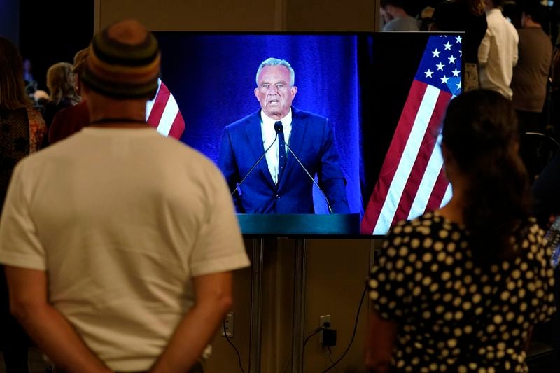 People watch on a monitor as Independent presidential candidate Robert F. Kennedy Jr. announces he is suspending his presidential campaign at a news conference Friday, Aug 23, 2024, in Phoenix. (AP Photo/Darryl Webb)