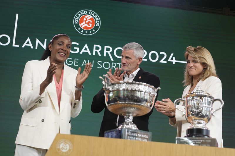 Former French athletic champion Marie-Jose Perec, left, Gilles Moretton, head of the French Tennis Federation (FFT), center, and tournament director Amelie Mauresmo applaud during the draw for the French Tennis Open at the Roland Garros stadium, Thursday, May 23, 2024 in Paris. The tournament starts Sunday May 26, 2024. (AP Photo/Thibault Camus)