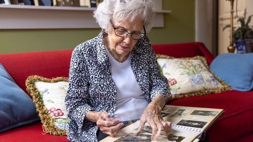 Plains resident Allene Haugabook, 93, showcases a scrapbook with photos taken during World War II on Saturday, February 25, 2023. In some of the photos she’s wearing clothes lent to her by Jimmy Carter's sister. (Arvin Temkar / arvin.temkar@ajc.com)