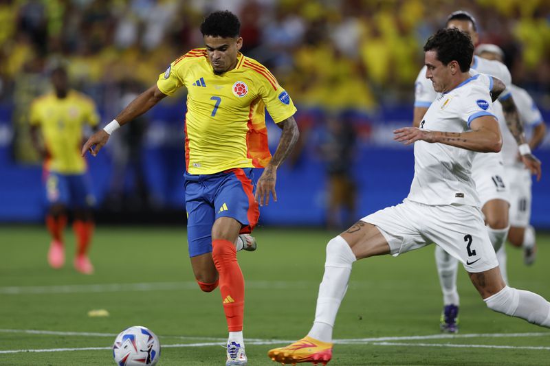 Colombia's Luis Diaz, left, evades Uruguay's Jose Gimenez during a Copa America semifinal soccer match in Charlotte, N.C., Wednesday, July 10, 2024. (AP Photo/Nell Redmond)