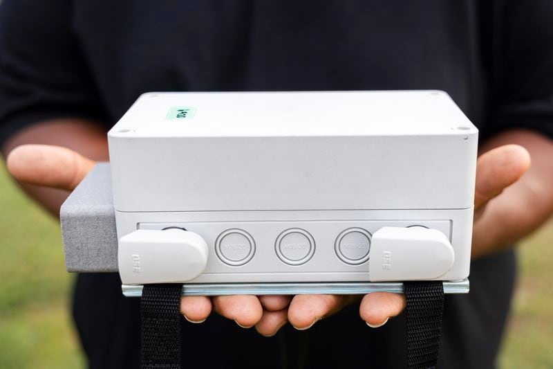 Ricky Johnson holds an air quality monitor that will collect samples in the Pleasantville area of Houston, Saturday, Aug. 17, 2024. (AP Photo/Annie Mulligan)