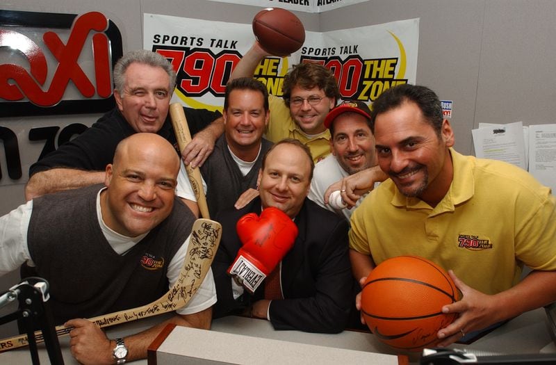 020424 - ATLANTA, GA -- The crew at Sports Talk 790 The Zone in 2002: Front row from left: Steak Shapiro (holding hockey stick), general manager Andrew Saltzman (with boxing glove), Nick Cellini (with basketball). Back row from left: Beau Bock ( holding bat), Mike Bell, Matt Edgar (holding football), and Chris Dimino (holding baseball). (AJC file 2002)