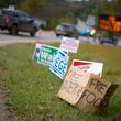 A makeshift cardboard sign leans up against campaign posters near a relief center on Thursday, Oct. 3, 2024, in Vilas, N.C. in the aftermath of hurricane Helene. In the final weeks of the presidential election, people in North Carolina and Georgia, influential swing states, are dealing with more immediate concerns: recovering from Hurricane Helene. (AP Photo/Chris Carlson)