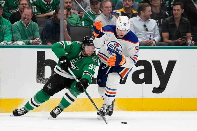 Dallas Stars center Matt Duchene (95) passes the puck next to Edmonton Oilers' Dylan Holloway (55) during the second period of Game 1 of the Western Conference finals in the NHL hockey Stanley Cup playoffs Thursday, May 23, 2024, in Dallas. (AP Photo/Tony Gutierrez)