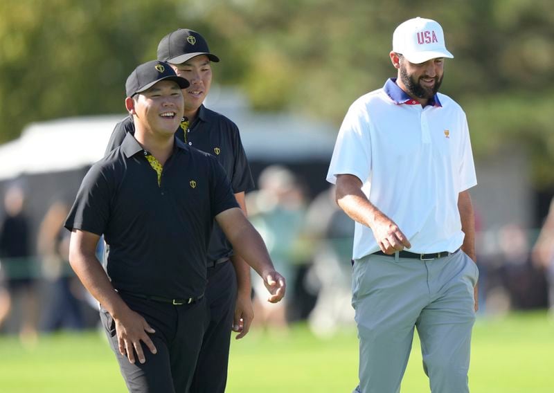 International team member Si Woo Kim, of South Korea, left, walks with partner Byeong Hun An, of South Korea, and United States team member Scottie Scheffler down the eighth fairway during the second round of the Presidents Cup golf tournament at Royal Montreal Golf Club in Montreal, Friday, Sept. 27, 2024. (Nathan Denette/The Canadian Press via AP)