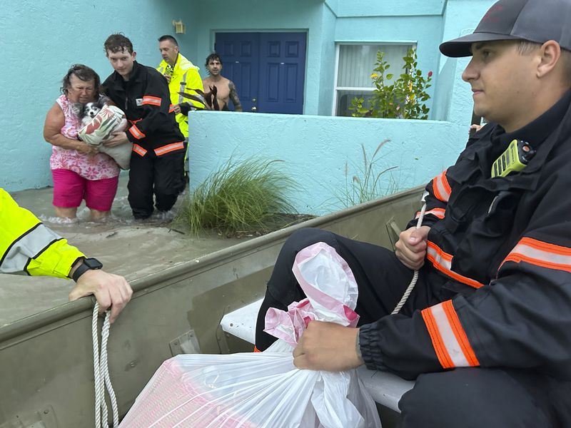 This photo provided by Venice Police Department rescue crews assist residents after conducting door-to-door wellness checks, in coastal areas that were flooded by Hurricane Helene on Friday, Sept. 27, 2024 in Venice, Fla . (Venice Police Department via AP)