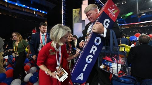 Ginger Howard signs on Georgia delegate marker as Brad Hughes holds during the final day of 2024 Republican National Convention, Thursday, July 18, 2024, in downtown Milwaukee, WI. (Hyosub Shin / AJC)