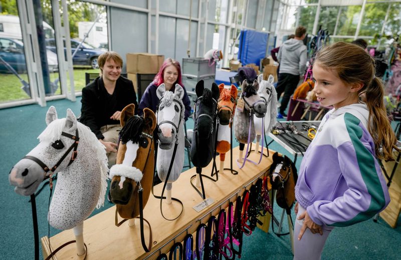 A vendor offers hobby horses for sale at the first German Hobby Horsing Championship in Frankfurt, Germany, Saturday, Sept. 14, 2024. (AP Photo/Michael Probst)