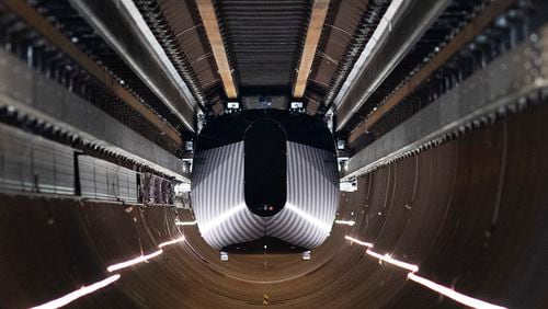 A test vehicle levitated by magnetic fields zips through a depressurized tube in a testing ground for a high-speed transit system during a press tour of a European test center for hyperloop transportation technology in Veendam, northern Netherlands, Friday, Sept. 6, 2024. (AP Photo/Peter Dejong)