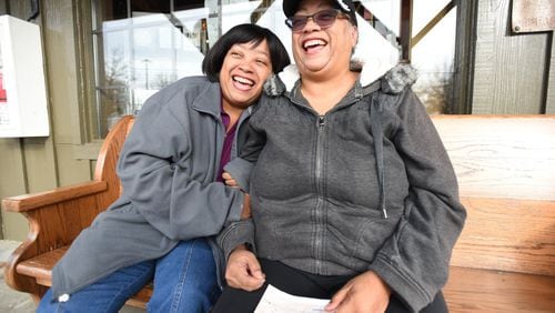 Twin sisters Priscilla (left) and Patricia Moses react as Patricia holds a gift donation from Keri Janton (not pictured), freelance writer and founder of Maximus Janton Foundation, in Norcross on Friday, January 10, 2020. The Moses sisters fostered and adopted dozens of children over the past 20 years and were featured in a December 2019 AJC story, have received a number of donations from AJC readers wanting to help the family.