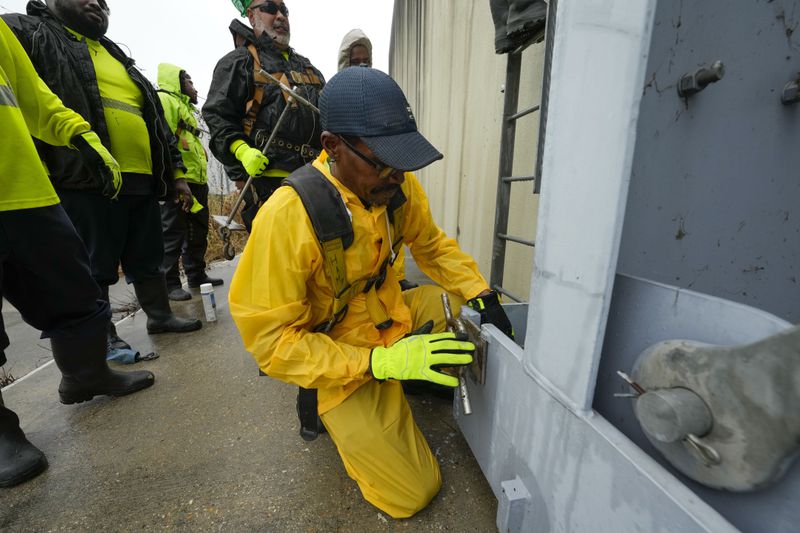 A workers from the Southeast Louisiana Flood Protection Authority-West locks a floodgates closed along the Harvey Canal, just outside the New Orleans city limits, in anticipation of Tropical Storm Francine, in Harvey, La., Tuesday, Sept. 10, 2024. (AP Photo/Gerald Herbert)