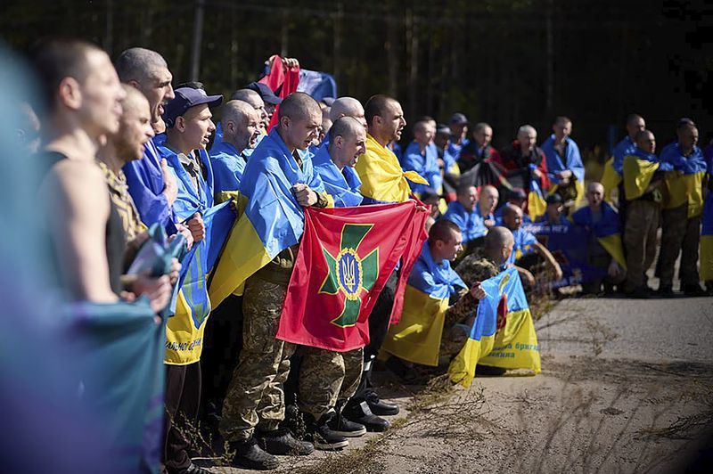 Ukrainians pose for a photo after being released in a prisoner exchange at an undisclosed location in Ukraine, Saturday Sept. 14, 2024. (Ukrainian Presidential Press Office via AP)