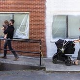 (L-R) Tyler Smith, holding Lennon, 2, and Grace Smith, pushing River, 5 months, walk into the building that will house their new bookstore in Chamblee on Friday, May 31, 2024. (Arvin Temkar / AJC)