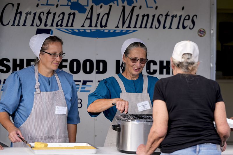 Loaves & Fishes food group serve meals for residents in the aftermath of Hurricane Helene, Wednesday, Oct. 2, 2024, in Lake Lure, N.C. (AP Photo/Mike Stewart)