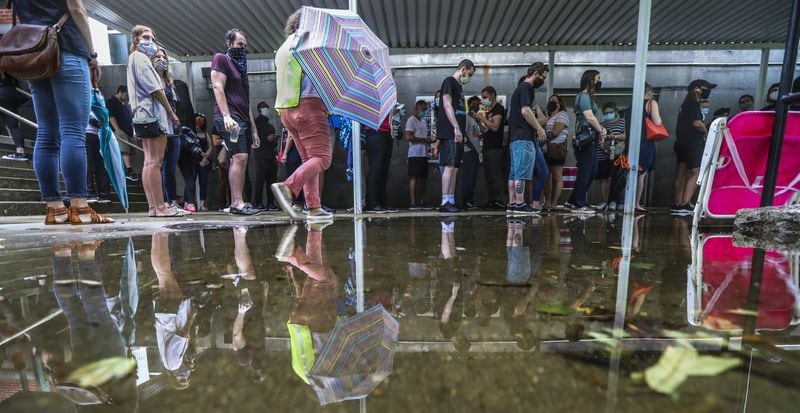Early voters line up in the rain on Friday, June 6, 2020 at Garden Hills Elementary School located at 285 Sheridan Dr NE, in Atlanta where the wait was between one and two hours. JOHN SPINK/JSPINK@AJC.COM