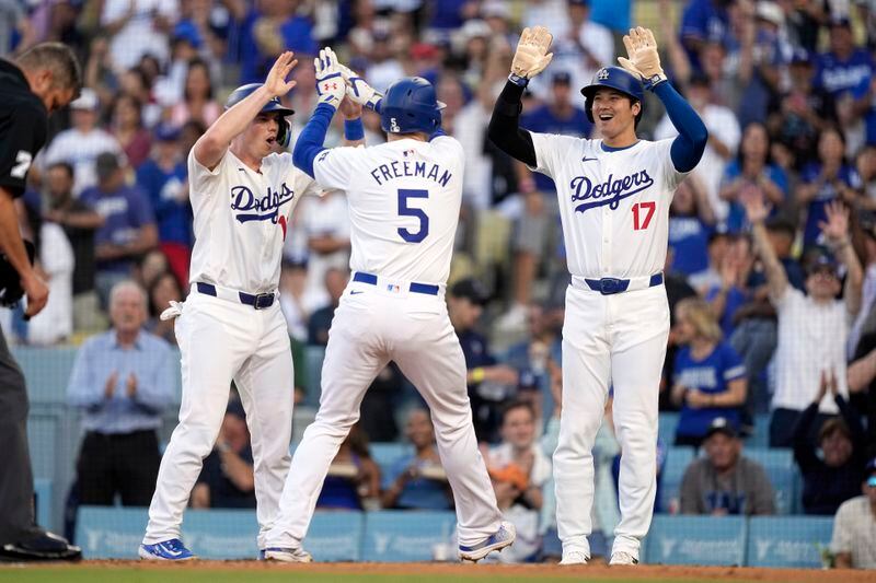 Los Angeles Dodgers' Freddie Freeman, center, is congratulated by Will Smith, left, and Shohei Ohtani, right, after hitting a three-run home run during the first inning of a baseball game against the Arizona Diamondbacks Wednesday, July 3, 2024, in Los Angeles. (AP Photo/Mark J. Terrill)