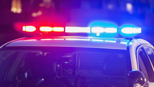 The roof of a police patrol car at night, with the blue and red lights flashing.