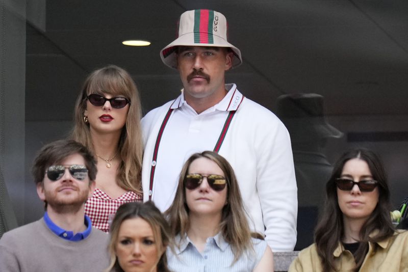 Taylor Swift, left, and Travis Kielce watch play between Jannik Sinner, of Italy, and Taylor Fritz, of the United States, during the men's singles final of the U.S. Open tennis championships, Sunday, Sept. 8, 2024, in New York. (AP Photo/Kirsty Wigglesworth)