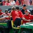 North Carolina State head coach Dave Doeren, rear right, checks on quarterback Grayson McCall (2) as he is carted from the field following an injury during the first half of an NCAA college football game in Raleigh, N.C., Saturday, Oct. 5, 2024. (AP Photo/Karl B DeBlaker)