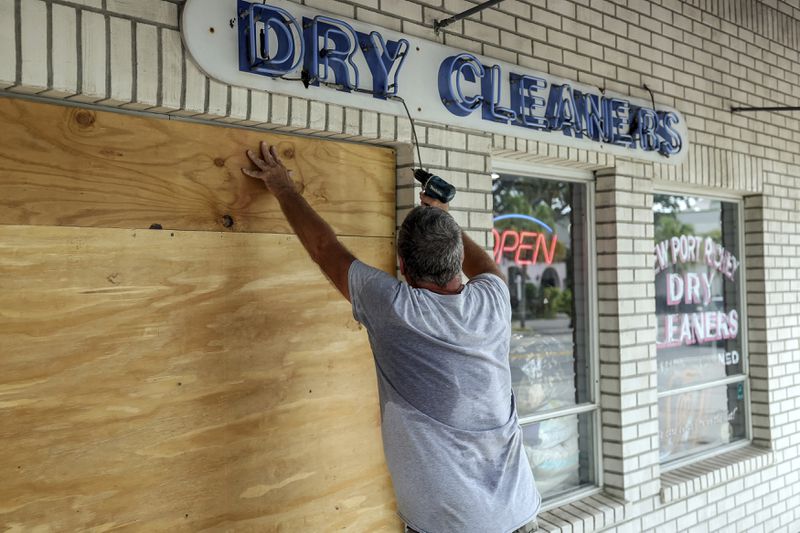 Jay McCoy puts up plywood in preparation for Hurricane Milton on Monday, Oct. 7, 2024, in New Port Richey, Fla. (AP Photo/Mike Carlson)