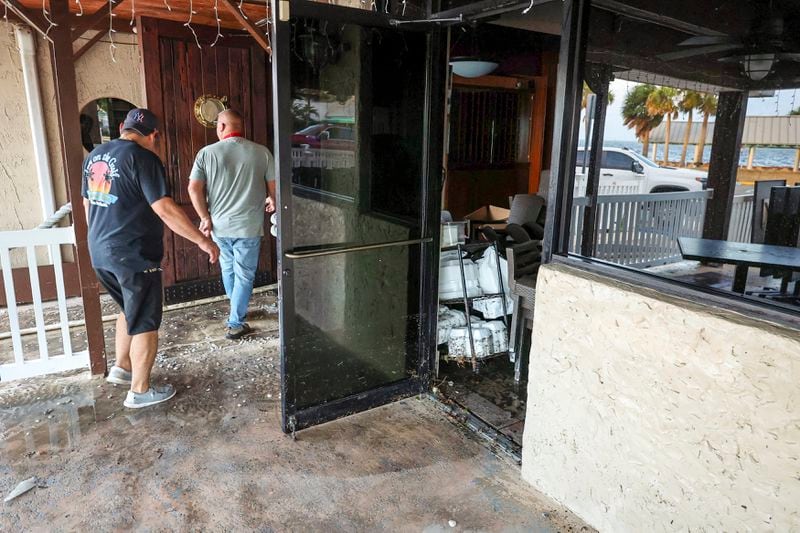 Staff of the Inn On The Gulf clean up after their restaurant flooded with surge from Hurricane Helene Friday, Sept. 27, 2024, in Hudson, Fla. (AP Photo/Mike Carlson)