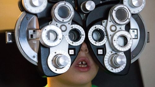 Aiden Crow, 7, is shown during a free eye exam in a mobile clinic at the Gwinnett County library in Snellville on Friday, Aug. 2, 2019. The free exams have no income requirement and provide glasses to children who need them. CASEY SYKES FOR THE ATLANTA JOURNAL-CONSTITUTION
