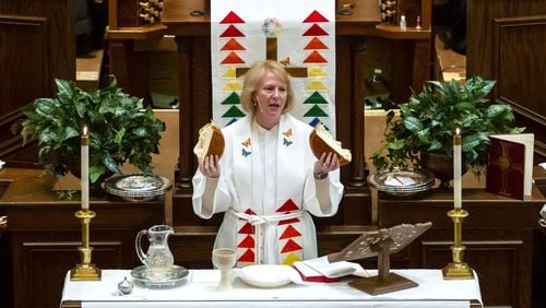 Bishop Sue Haupert-Johnson prays over a lof of bread before communion is served Sunday at the St. Mark United Methodist Church in Atlanta March 3, 2019.