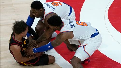 Atlanta Hawks guard Trae Young (11) battles New York Knicks guards Elfrid Payton (6) and RJ Barrett (9) for the ball during the first half of Monday's game in Atlanta.