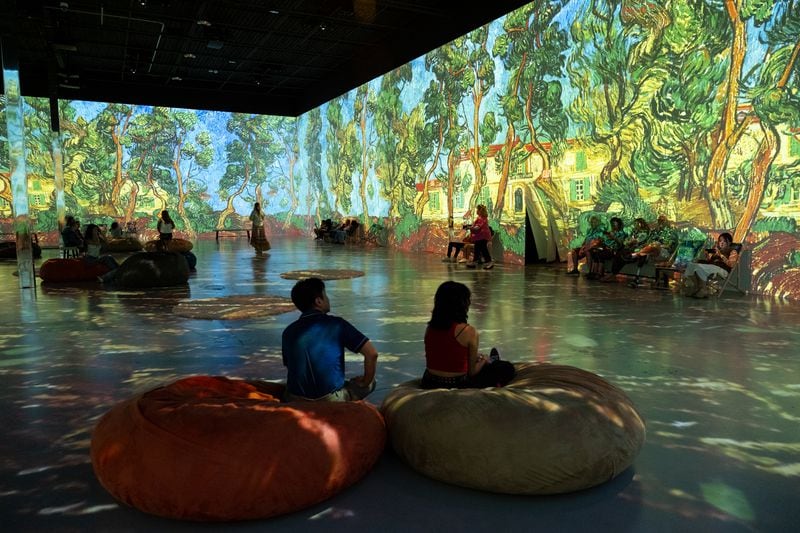 People take in the main room of Van Gogh: The Immersive Experience at Exhibition Hub Art Center Atlanta in Doraville on Monday, July 31, 2023.   (Ben Gray / Ben@BenGray.com)