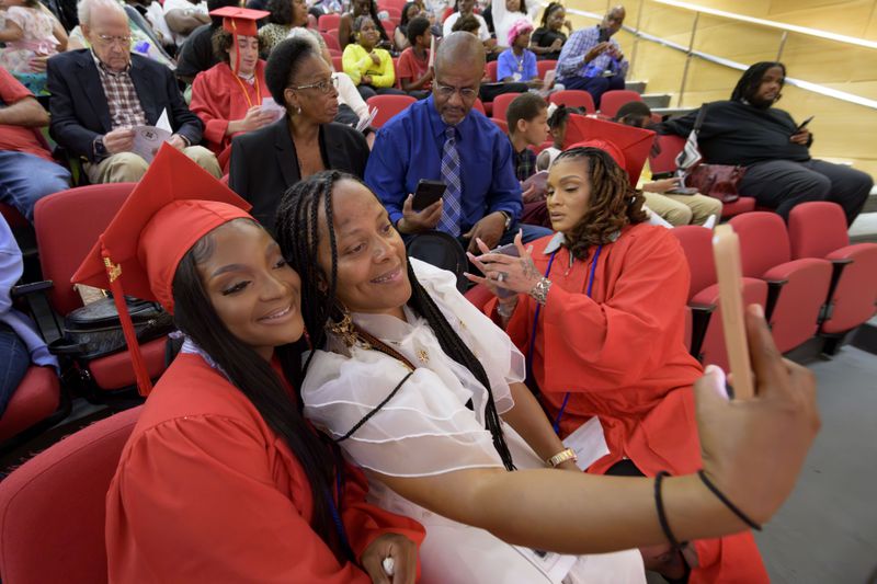 Gradute Chamaine Brown, left, poses with friend Christolyn Wilson, next to Danielle McGinnis, Brown's mother and also a graduate, before a high school equivalency (HiSET) diploma graduation ceremony for the Youth Empowerment Project (YEP) in New Orleans, Thursday, June 27, 2024. (AP Photo/Matthew Hinton)