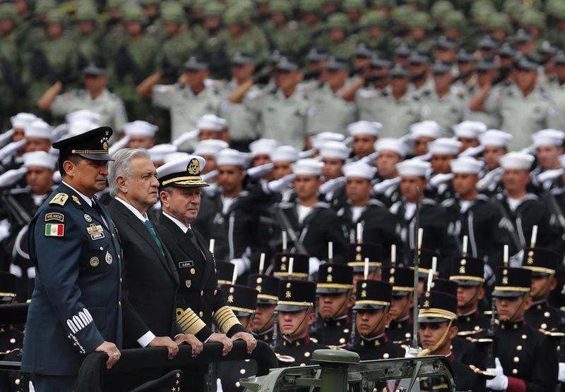 FILE - Mexican President Andres Manuel Lopez Obrador stands between Defense Secretary Luis Crescencio Sandoval, left, and Navy Secretary Vidal Francisco Soberon during the Independence Day military parade at the Zocalo in Mexico City, Sept. 16, 2019. (AP Photo/Marco Ugarte, File)