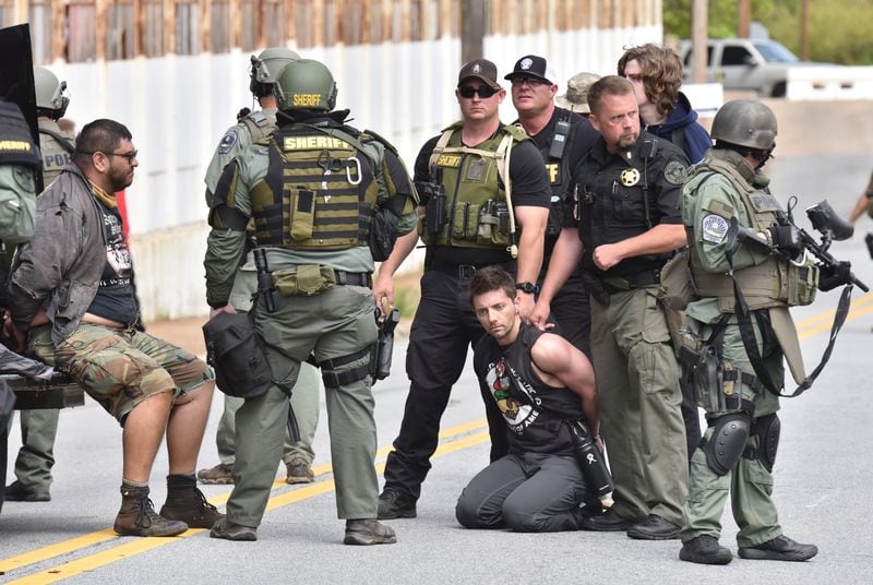 Counterprotesters are held by law enforcement officers as the National Socialist Movement holds a rally at Greenville Street Park in downtown Newnan on Saturday, April 21, 2018. The  far-right hate group also drew anti-fascist demonstrators as well as hundreds of police officers.