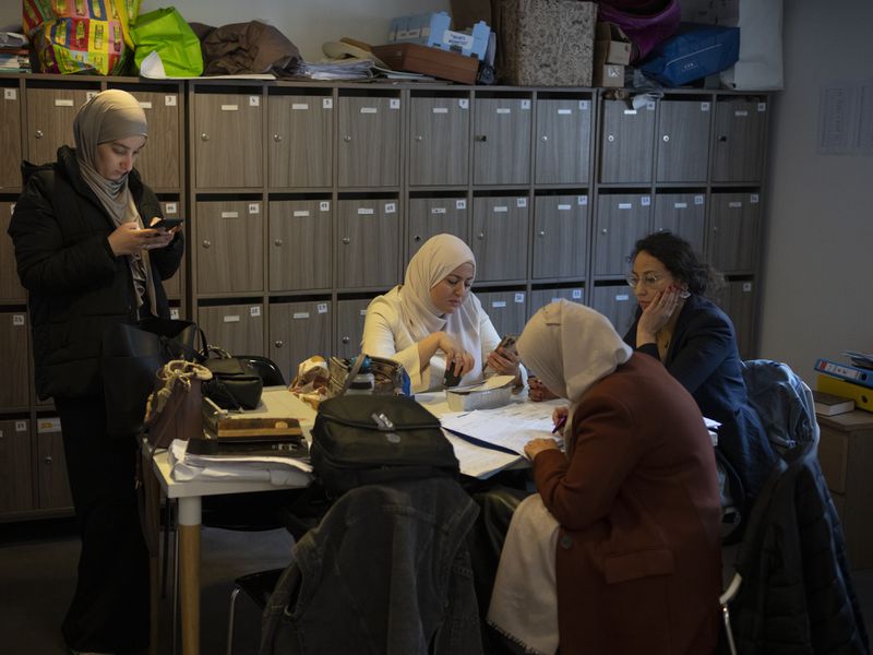 Teachers work in the teachers lounge at Ibn Khaldoun, a private Muslim school, in Marseille, southern France, Thursday, April 18, 2024. (AP Photo/Daniel Cole)