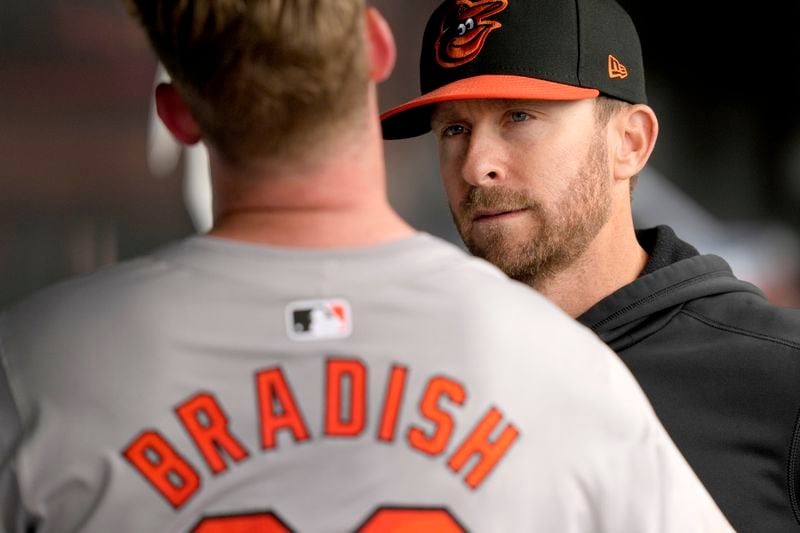 Baltimore Orioles pitching coach Drew French, right, listens to pitcher Kyle Bradish in the dugout during the fifth inning of a baseball game against the Chicago White Sox, Sunday, May 26, 2024, in Chicago. (AP Photo/Charles Rex Arbogast)