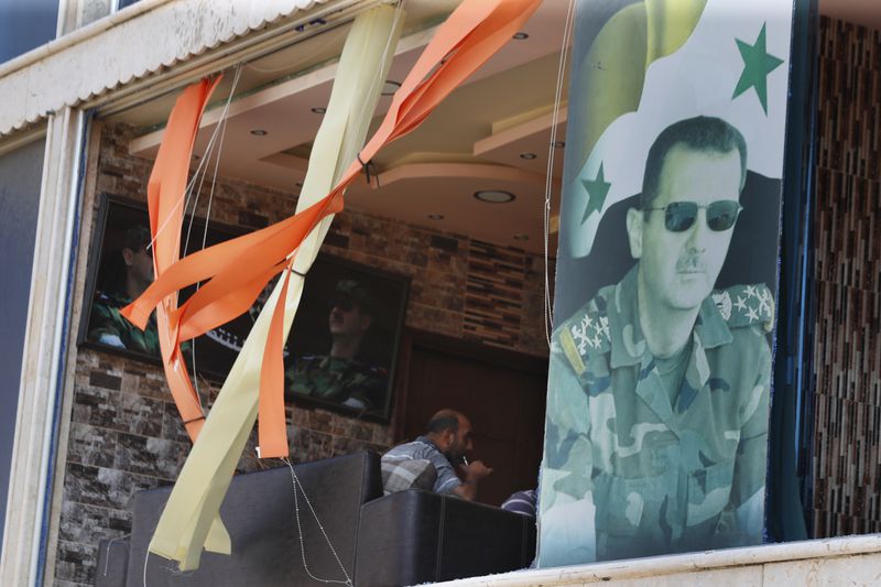 A poster shows Syrian President Bashar Assad installed at a broken window in the town of Masyaf, Syria, Monday, Sept. 9, 2024. Syrian state news agency SANA says that Israeli strikes hit several areas in central Syria Sunday night, damaging a highway in Hama province and sparking fires. (AP Photo/Omar Sanadiki)