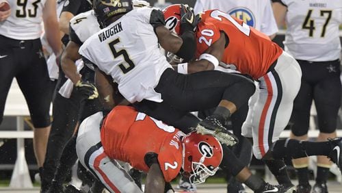 October 6, 2018 Athens - Vanderbilt running back Ke'Shawn Vaughn (5) gets tackled by Georgia defensive back Richard LeCounte (2) and Georgia defensive back J.R. Reed (20) in the first half during a NCAA college football game at Sanford Stadium in Athens on Saturday, October 6, 2018. HYOSUB SHIN / HSHIN@AJC.COM