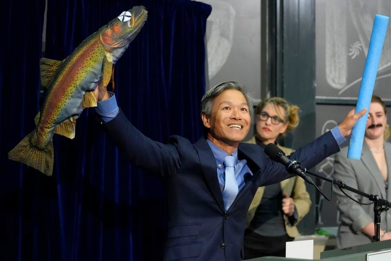 Professor James Liao displays a stuffed fish while accepting a prize for physics for demonstrating and explaining the swimming abilities of a dead trout during a performance at the Ig Nobel Prize ceremony at Massachusetts Institute of Technology in Cambridge, Mass., Thursday, Sept. 12, 2024. (AP Photo/Steven Senne)