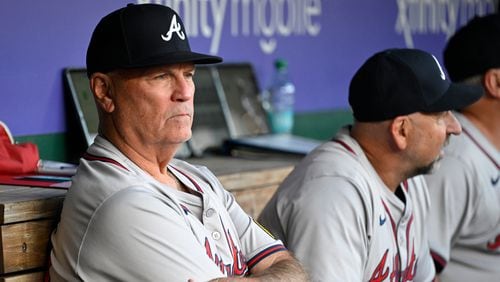 Atlanta Braves manager Brian Snitker, left, sits in the dugout waiting for the start of a baseball game against the Washington Nationals, Tuesday, Sept. 10, 2024, in Washington. (AP Photo/John McDonnell)