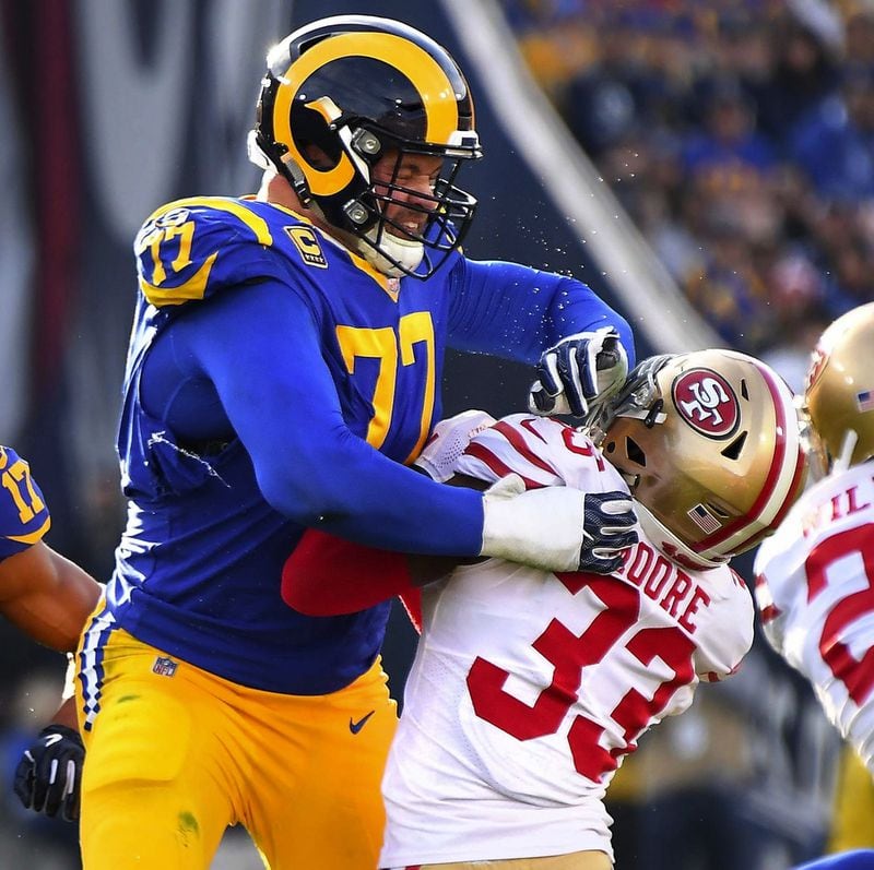 Tekel ofensif Los Angeles Rams Andrew Whitworth (77) melakukan perdagangannya dengan mengorbankan Tarvarius Moore (33) dari San Francisco 49ers dalam pertandingan tahun 2018 di Los Angeles Memorial Coliseum. (Wally Skalij/Los Angeles Times/TNS)