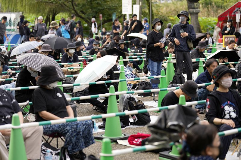 Visitors wait to see the giant pandas Ri Ri and Shin Shin at Ueno Zoo, a day before their return to China, Saturday, Sept. 28, 2024, in Tokyo. (AP Photo/Eugene Hoshiko)