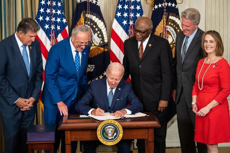 President Joe Biden, flanked by, from left, Sen. Joe Manchin (D-WV), Senate Majority Leader Chuck Schumer (D-NY), House Majority Whip Jim Clyburn (D-SC), Rep. Frank Pallone (D-NJ), and Rep. Kathy Castor (D-FL), delivers remarks and signs the Inflation Reduction Act of 2022 into law in the State Dining Room of the White House on Tuesday, Aug. 16, 2022, in Washington, D.C. (Kent Nishimura/Los Angeles Times/TNS)