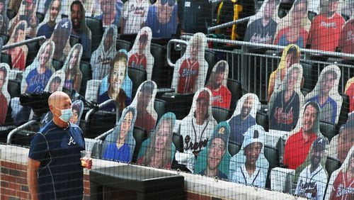 Braves manager Brian Snitker takes in the strange scene of 1,500 cardboard cutouts of fans in the otherwise empty seats at Truist Park prior to a 2020 game. (Curtis Compton/ccompton@ajc.com)